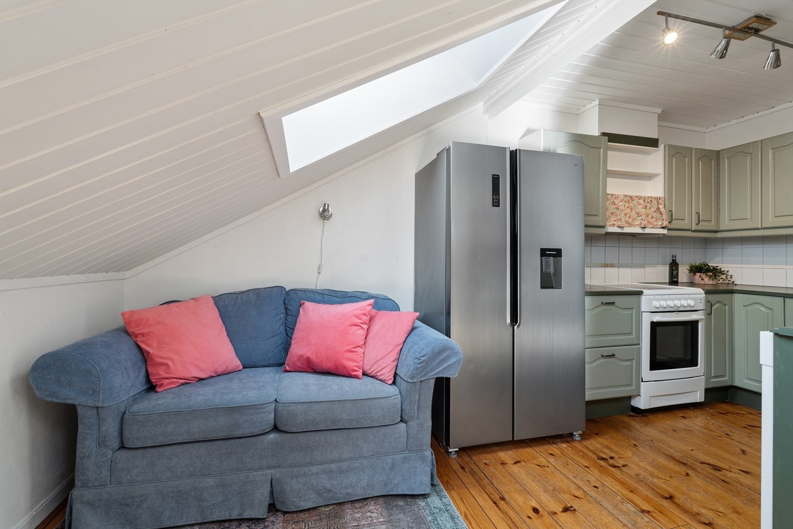 Takhøye skap og smarte løsninger utnytter plassen godt i denne sjarmerende loftsleiligheten med skråtak. Galleribilde