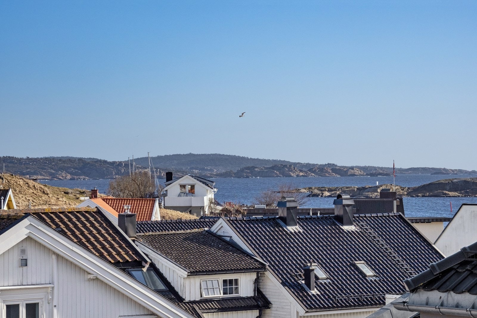 Utsikt over de sjarmerende takene i Stavern og glimt av havet. Galleribilde