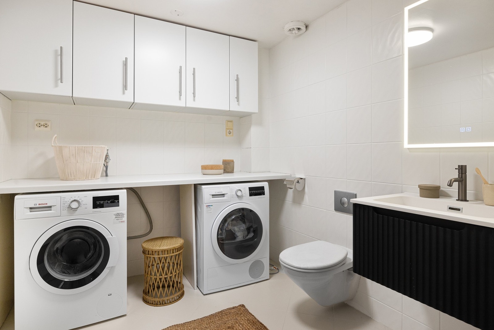 Badet har også vaskeromsinnredning med laminat benkeplate og overskap. Under benkeplaten er det opplegg og plass til vaskemaskin og tørketrommel. Galleribilde