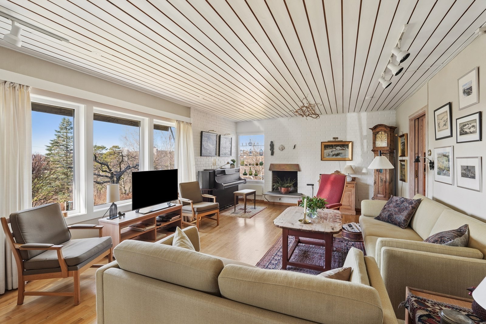 Det er parkett på gulv og åpen peis i stue Galleribilde