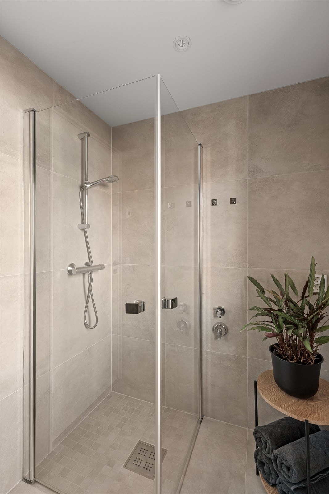 Badet i denne etasjen har fliser på vegg og er utstyrt med servant, vegghengt toalett, dusjhjørne og opplegg for vaskemaskin. Galleribilde
