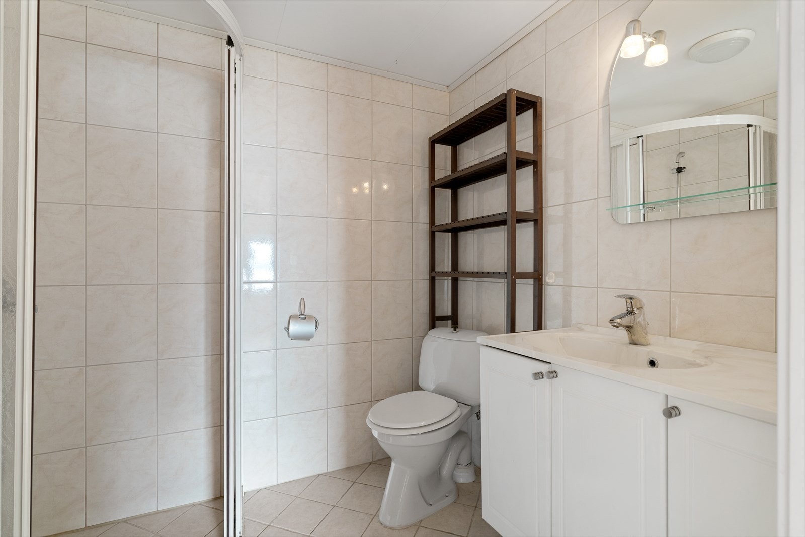 Badet er utstyrt med dusjhjørne, toalett og servantskap. Galleribilde