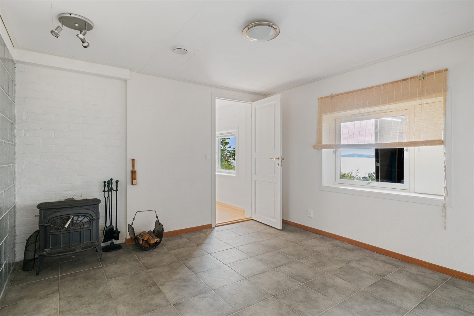 Lys stue på 16 m² med vedovn, som både varmer og skaper en innbydende stemning. Galleribilde