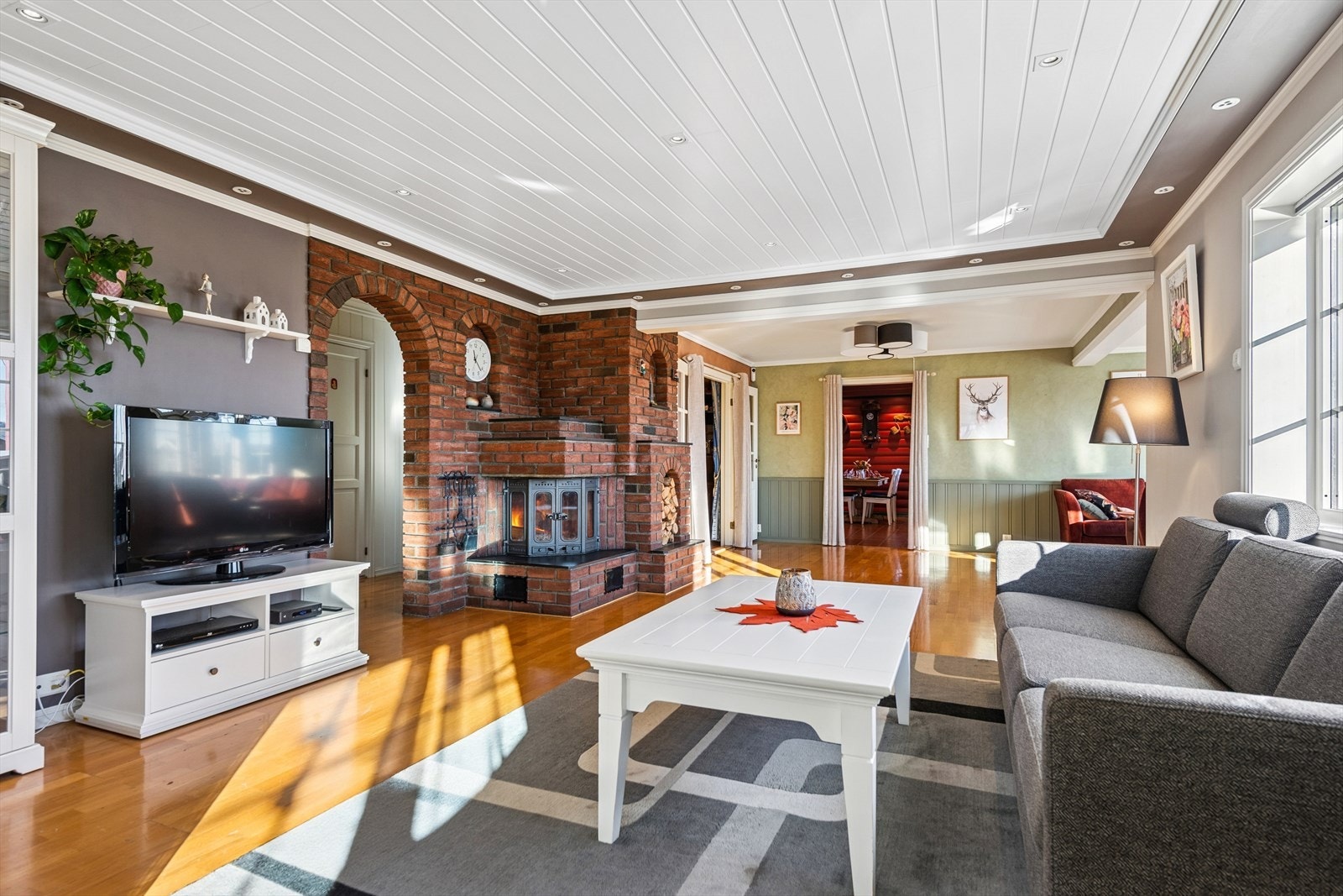 Stuen er et av boligens samlingspunkter, med en av boligens tre peiser som gir god varme. Galleribilde