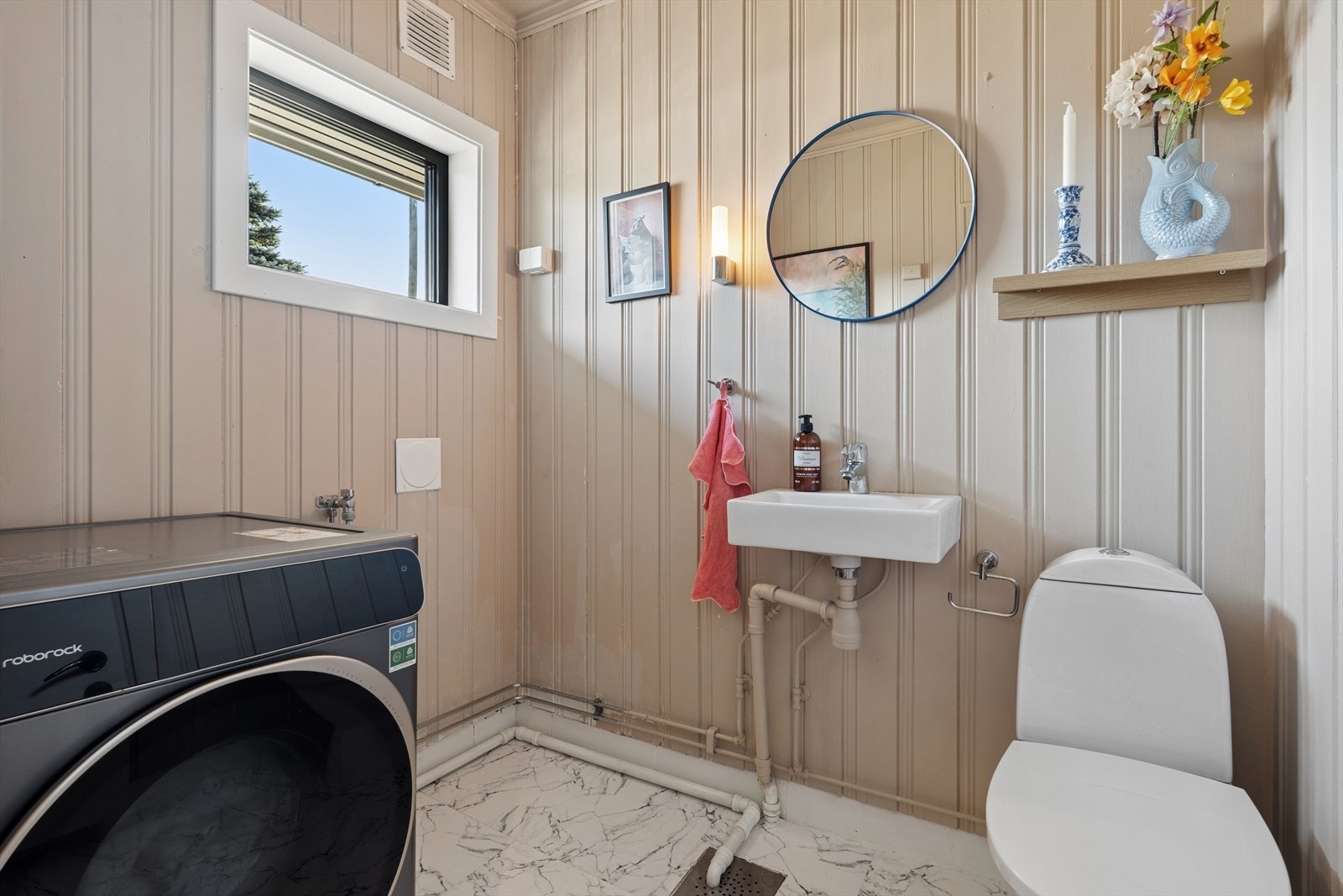 Separat wc-rom med gulvstående toalett, enkel servantinnredning og opplegg for vaskemaskin. Her er det også gulvvarme. Galleribilde