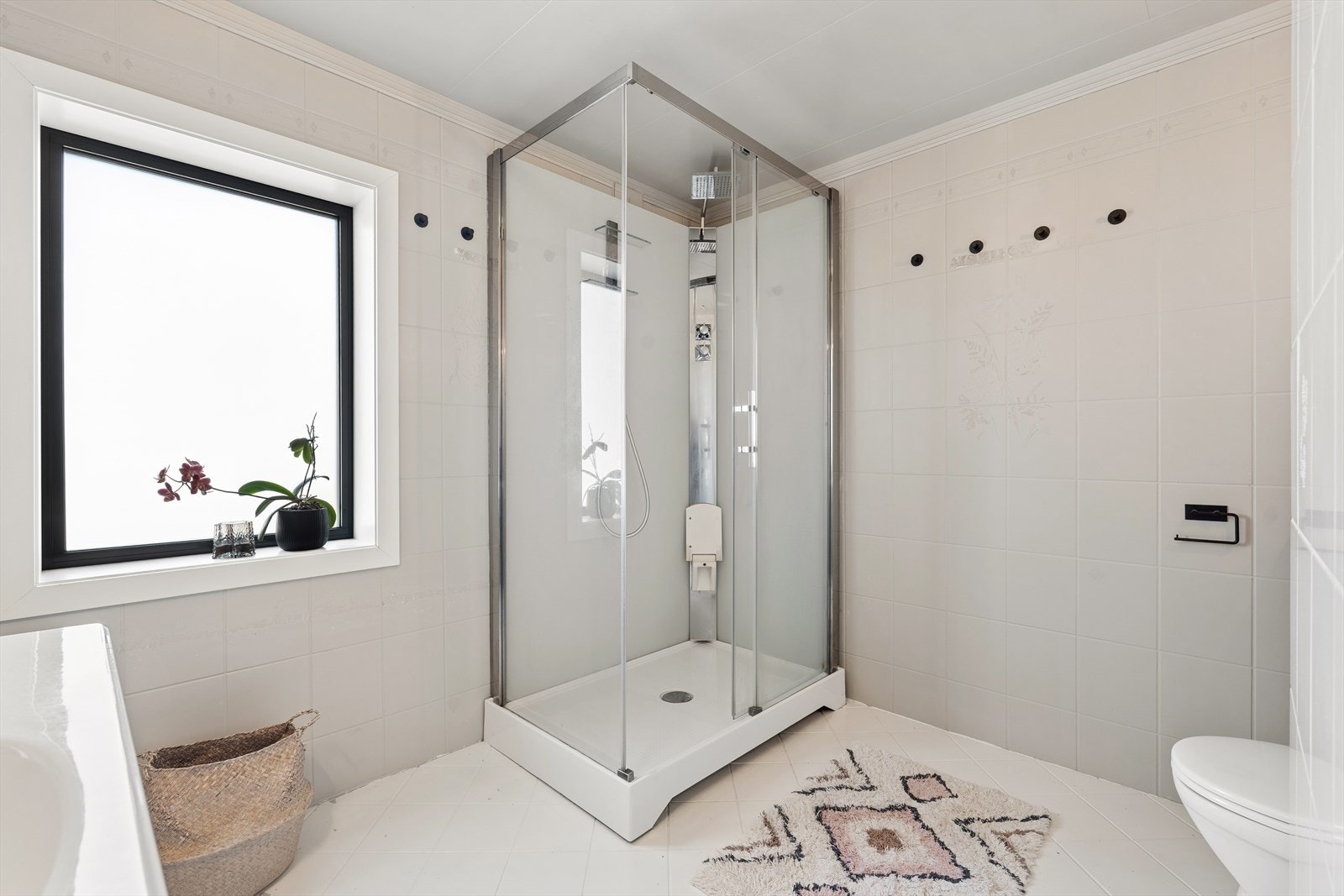 Delikat flislagt bad utstyrt med dusjkabinett og gulvstående toalett. Det er behagelige varmekabler i gulv. Galleribilde