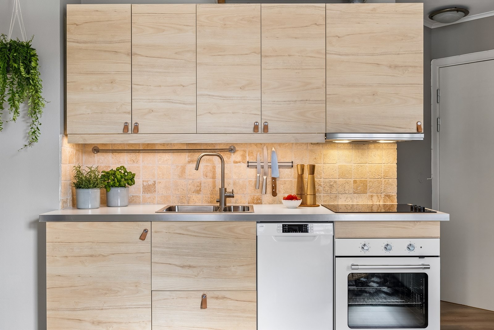 Tidløst kjøkken med integrerte hvitevarer som stekeovn, oppvaskmaskin og kombinert kjøl og fryseskap. Hvitevarene medfølger handelen. Galleribilde