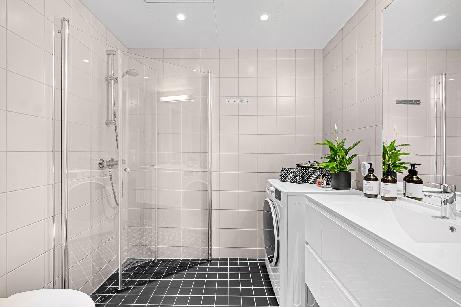 Badet har innredning med servantseksjon, vegghengt WC og dusjnisje med glassdører. Opplegg for vaskemaskin Galleribilde