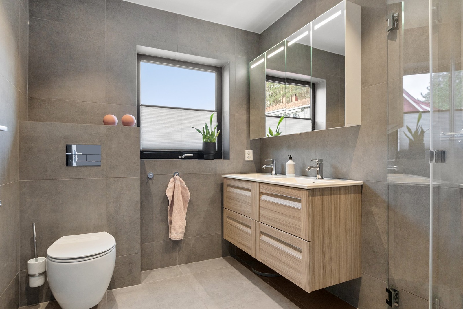 Moderne bad med flislagte overflater, gulvvarme og vindu. Galleribilde