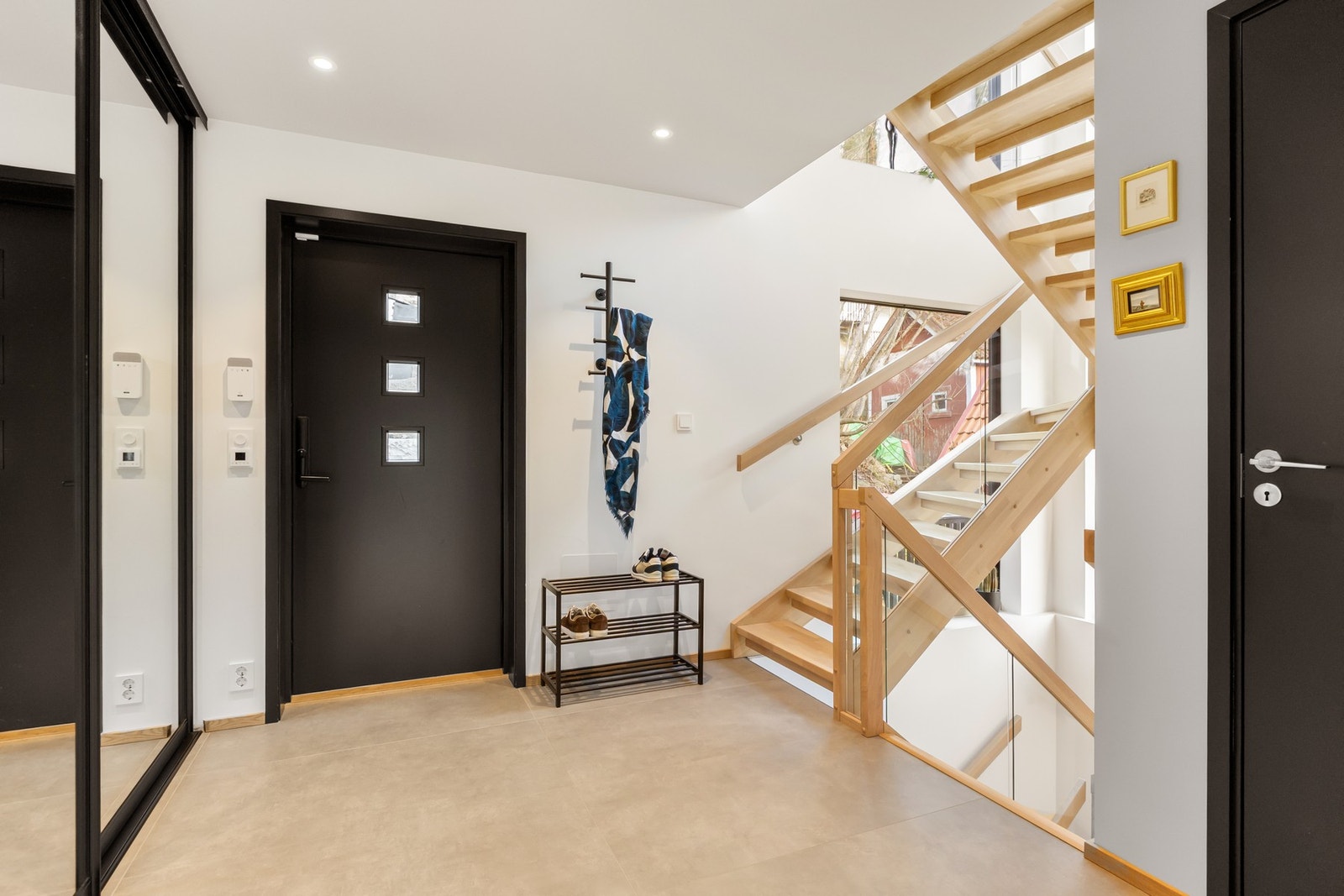 Man ankommer boligen via en lys og romslig entré med skyvedørsgarderobe med speilfronter. Galleribilde