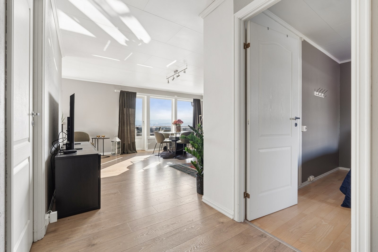 Velkommen inn i en lys og innbydende entré med praktisk oppbevaring og direkte adkomst til det åpne oppholdsrommet Galleribilde