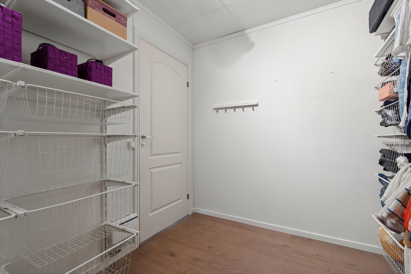 Praktisk walk-in-garderobe med god oppbevaringsplass i åpne hyllesystemer og kurvløsninger. Galleribilde