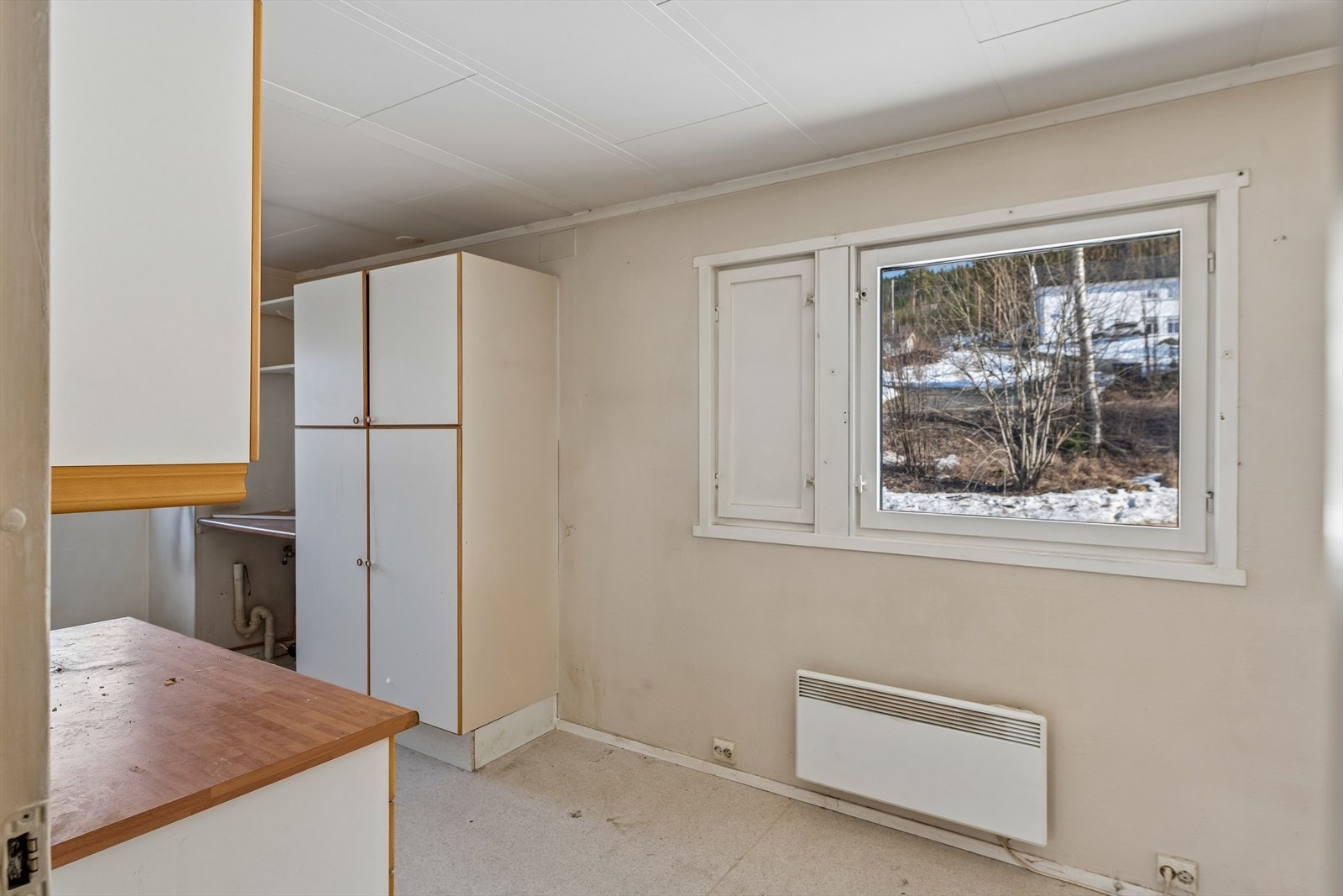 Kjøkkeninnredningen har malte laminerte fronter og laminatbenkeplate, med fliser over benken. Galleribilde