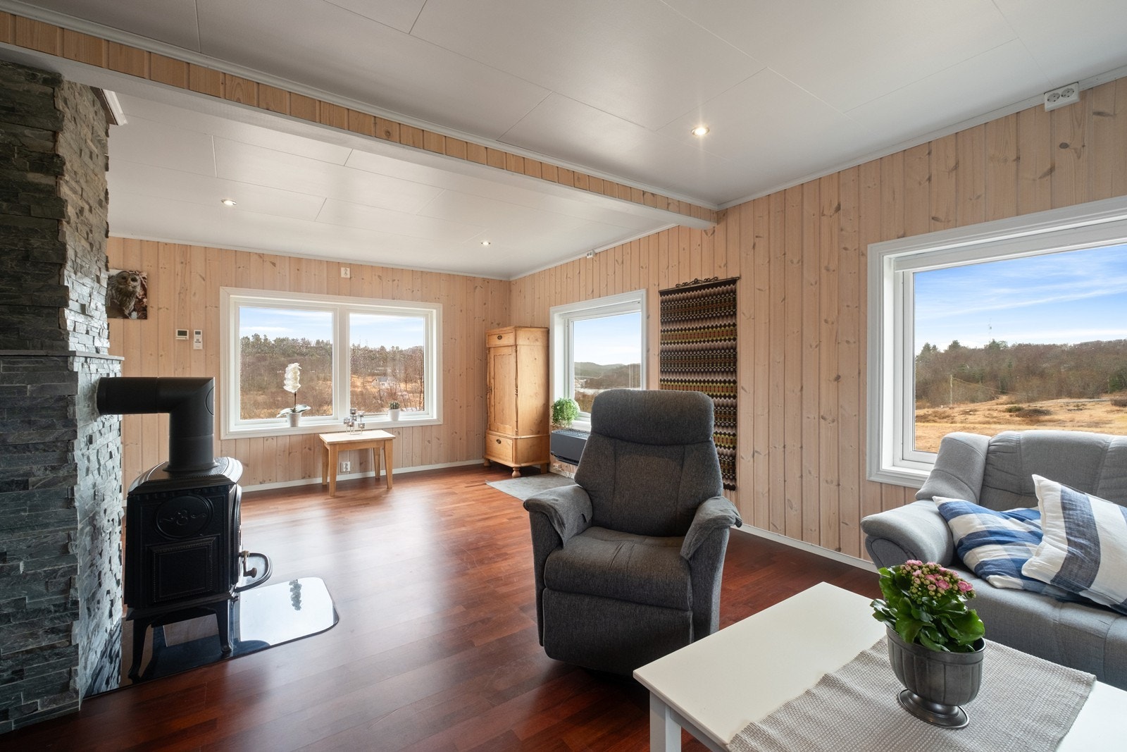 Vinduer er montert på tre av stuens vegger, slik man får rikelig med dagslys og gjennomlysing i rommet. Galleribilde