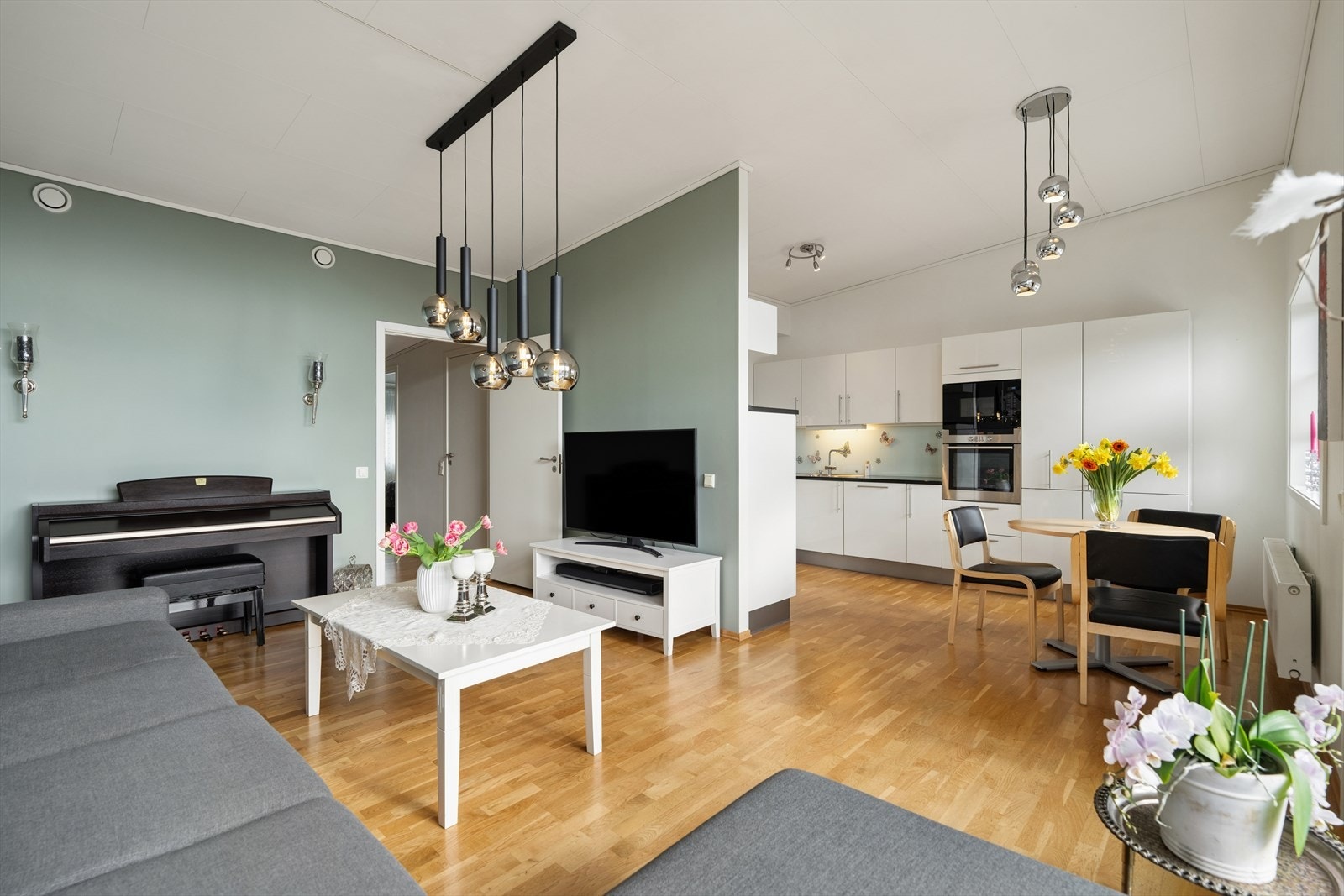 Den åpne løsningen mellom stue og kjøkken skaper et sosialt og moderne oppholdsrom. Her flyter sonene naturlig over i hverandre, noe som gir boligen en luftig helhetsfølelse og god bevegelsesfrihet. Galleribilde