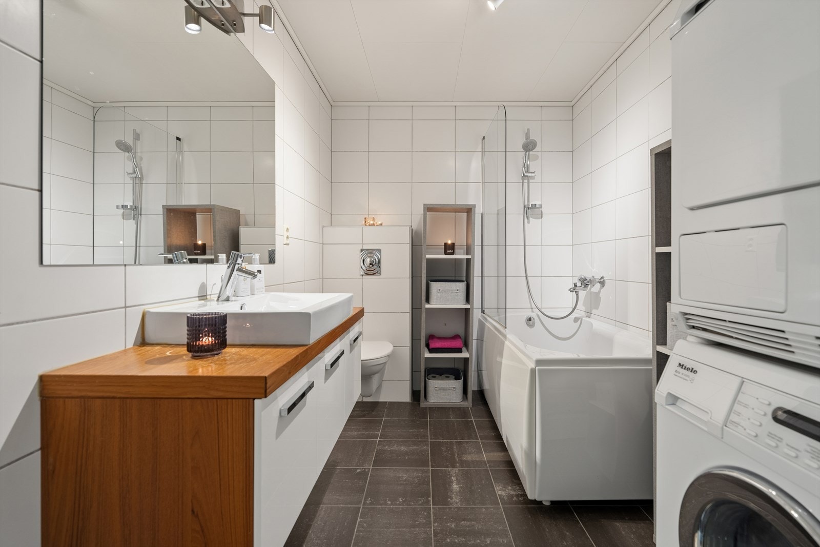 Badet, som er fra byggeåret, fremstår tidsmessig og funksjonelt med flislagte vegger og gulv, samt gulvvarme som gir ekstra komfort. Galleribilde