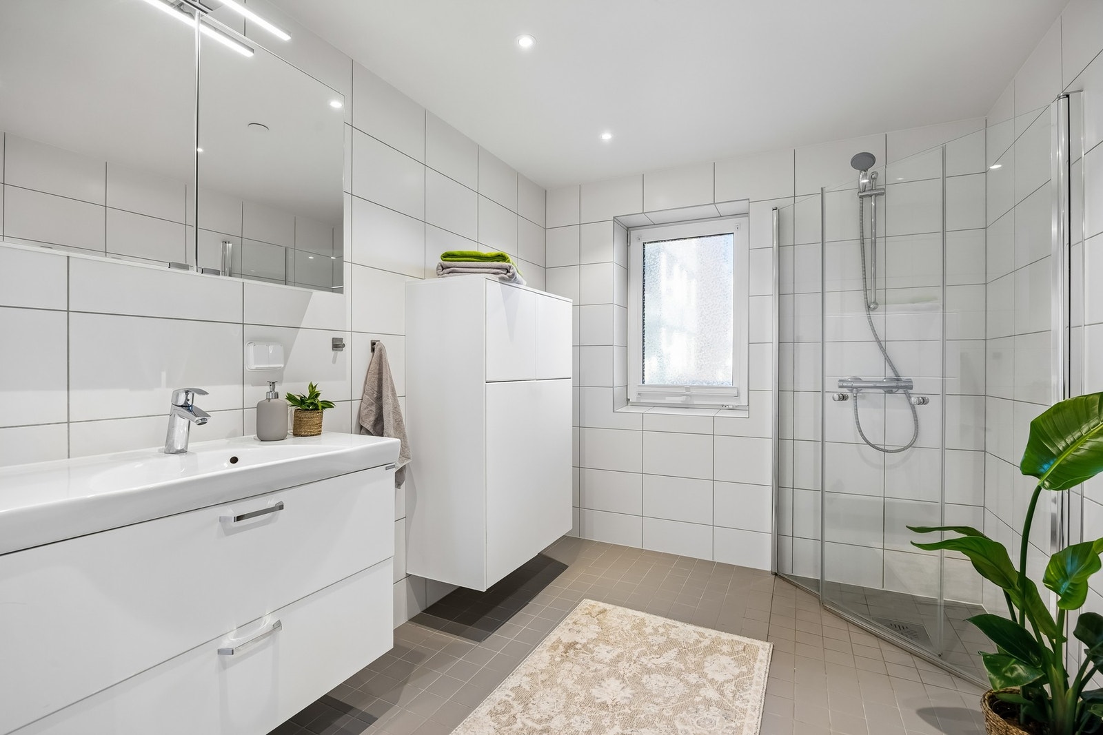 Badet har gulvvarme, downlights og et dusjhjørne med innfellbare glassvegger. Galleribilde