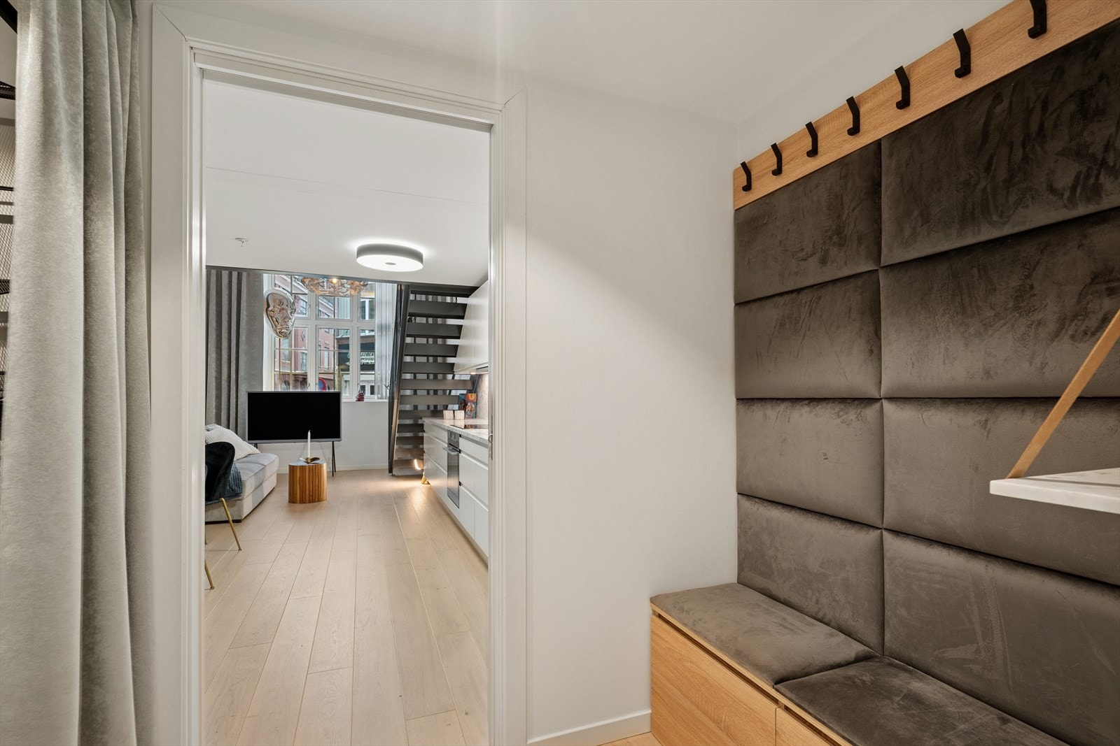 Entréen til leiligheten er av fin størrelse og har snekkerlaget møblement med benk og knaggrekke. Galleribilde