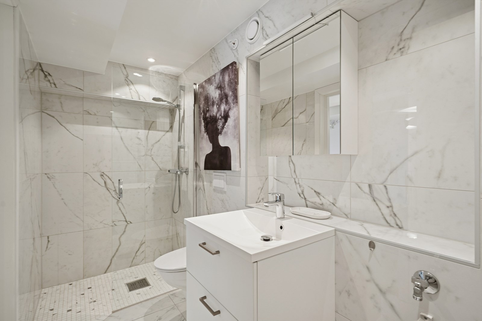 Påkostet og rålekkert utført bad med marmorfliser og detaljer i krom. Galleribilde