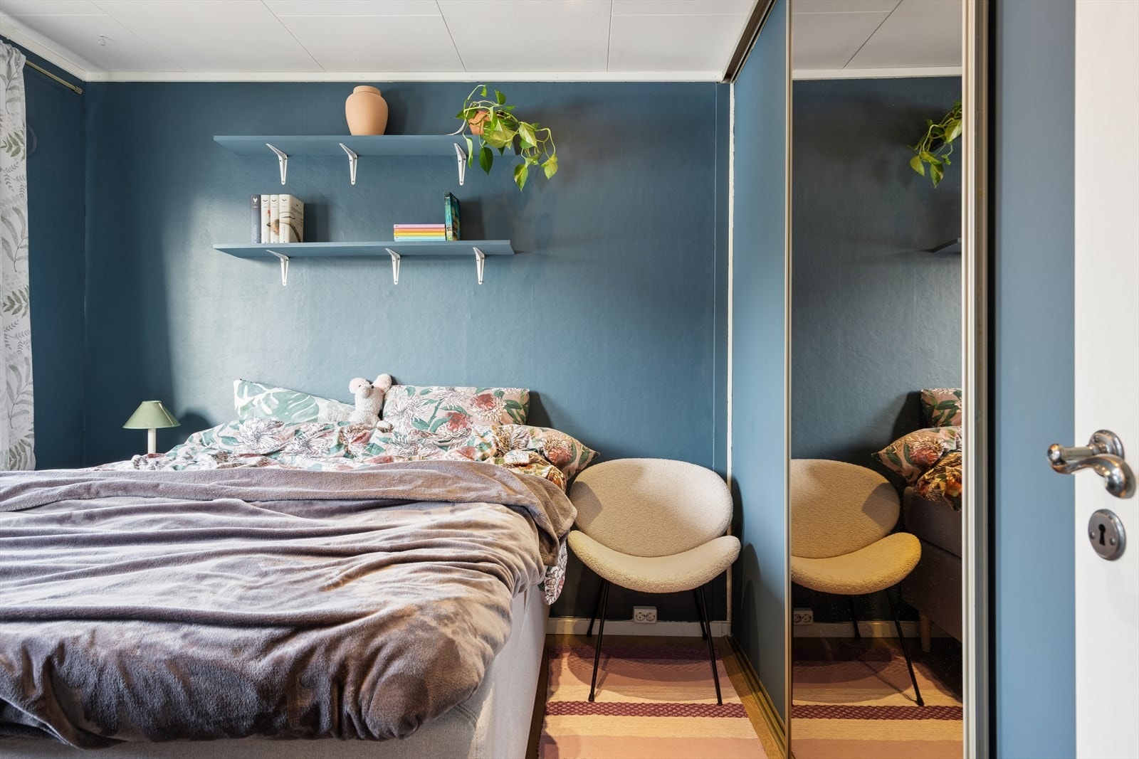 En romslig skyvedørsgarderobe med speilfronter gir rikelig med oppbevaringsplass. Galleribilde