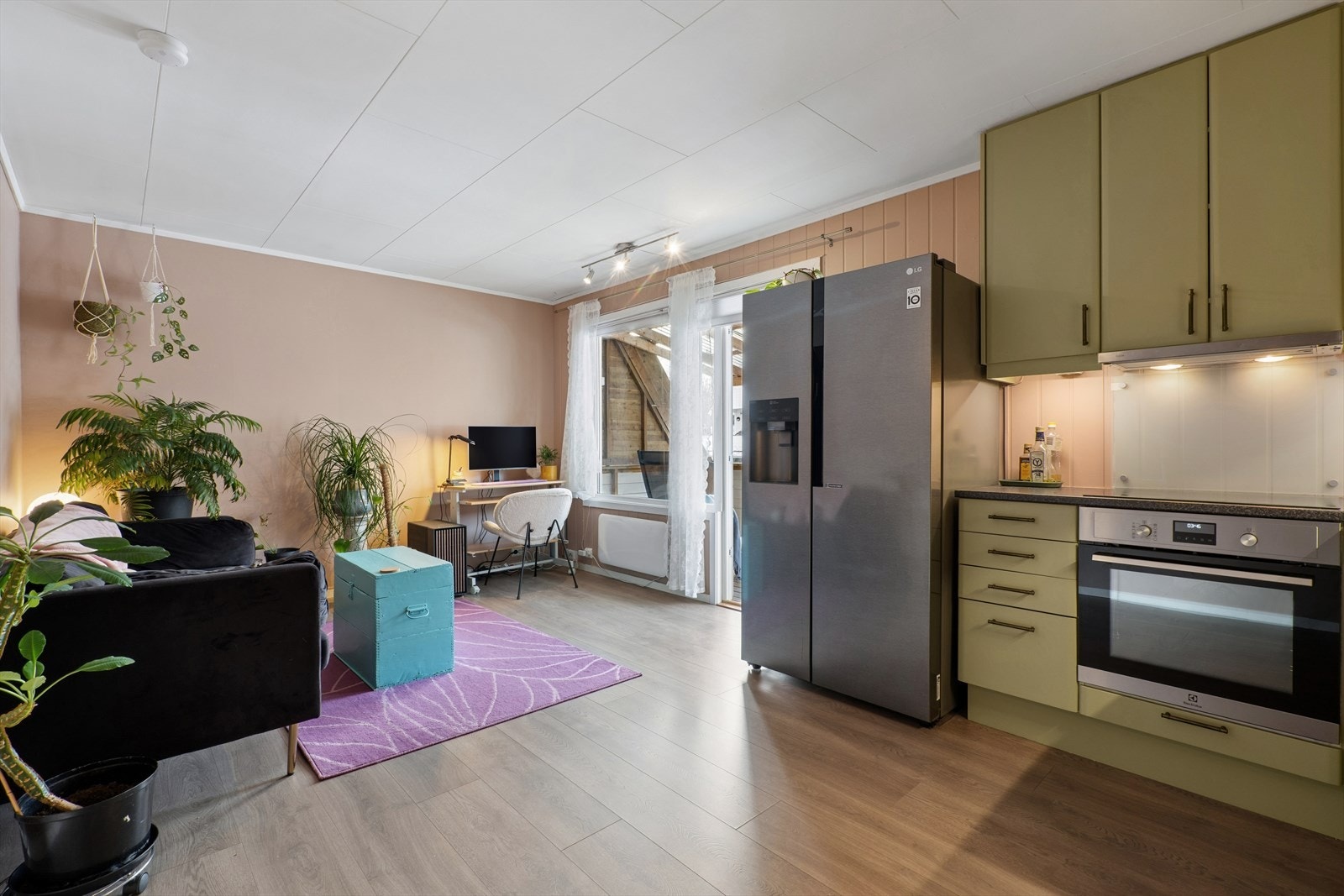 Leiligheten byr på en åpen og innbydende løsning mellom stue og kjøkken, med et gjennomgående laminatgulv som skaper en helhetlig følelse. Galleribilde