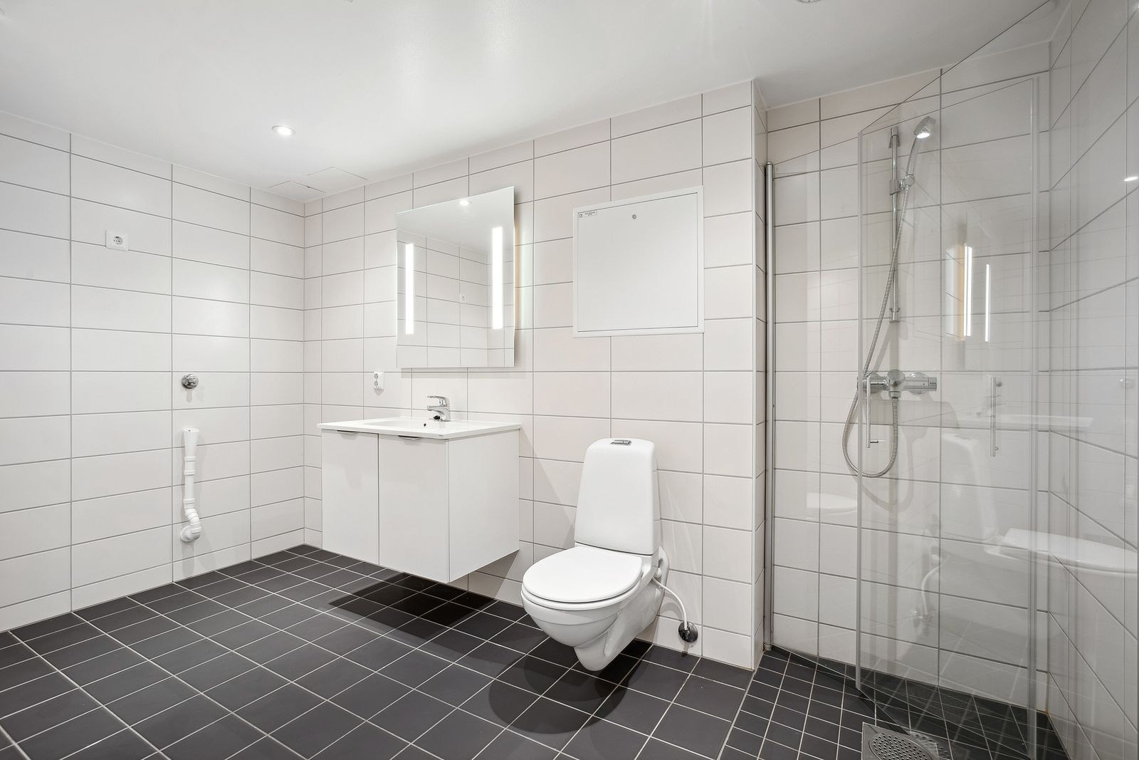 Det flislagte badet fra 2018 har vannbåren gulvvarme, dusjhjørne med innsvingbare glassdører og opplegg for vaskemaskin. Galleribilde