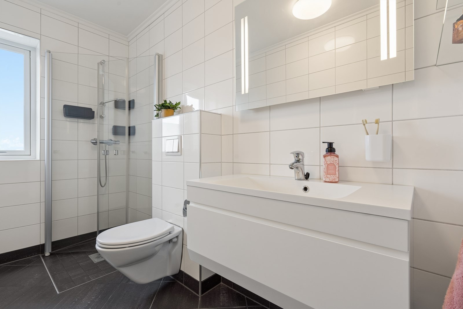 Flislagt baderom i et tidløst uttrykk som kombineres med vaskerom. Varmekabler i gulv. Galleribilde