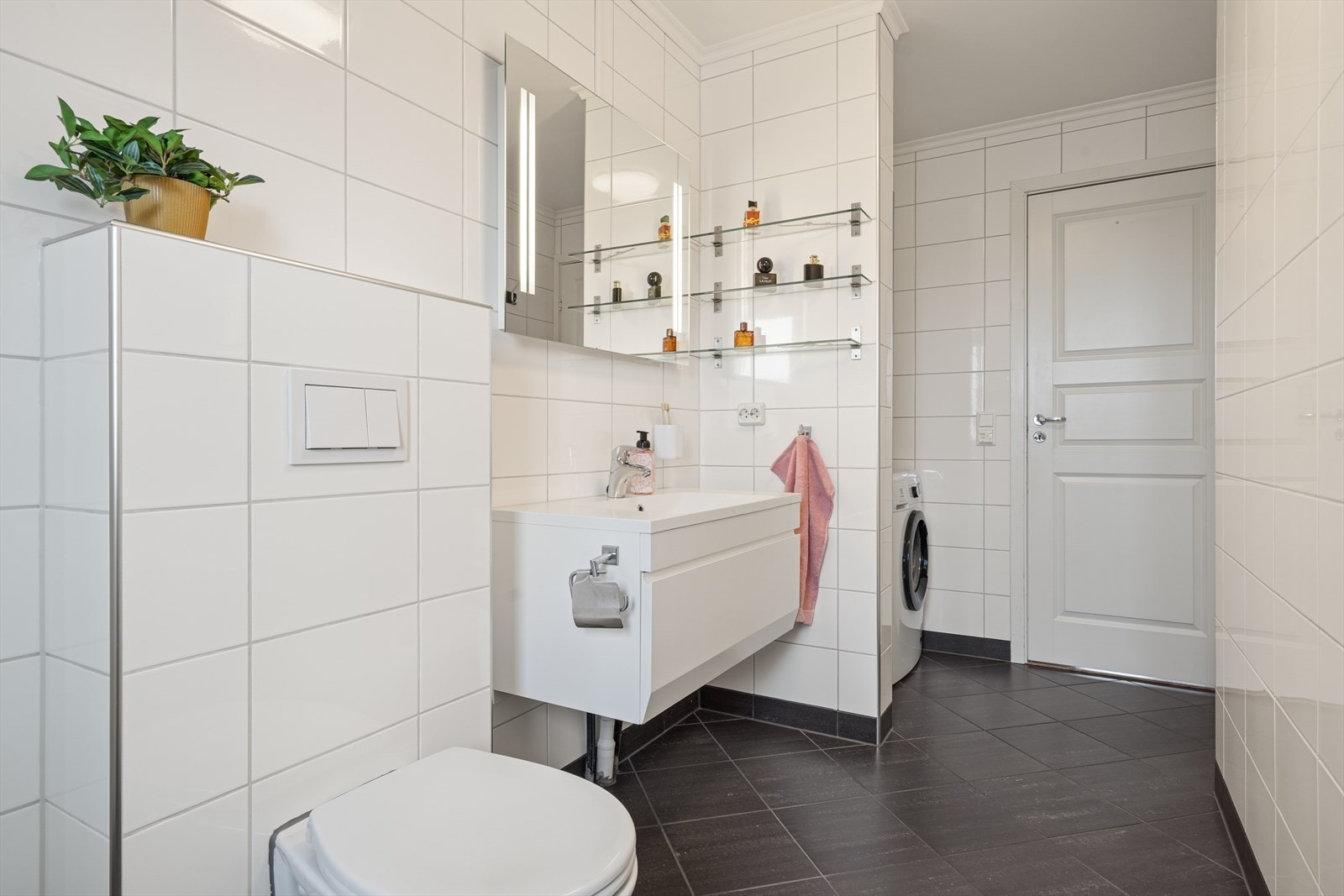 Badet er utstyrt med toalett, baderomsinnredning, dusjhjørne og opplegg til vaskemaskin. Galleribilde