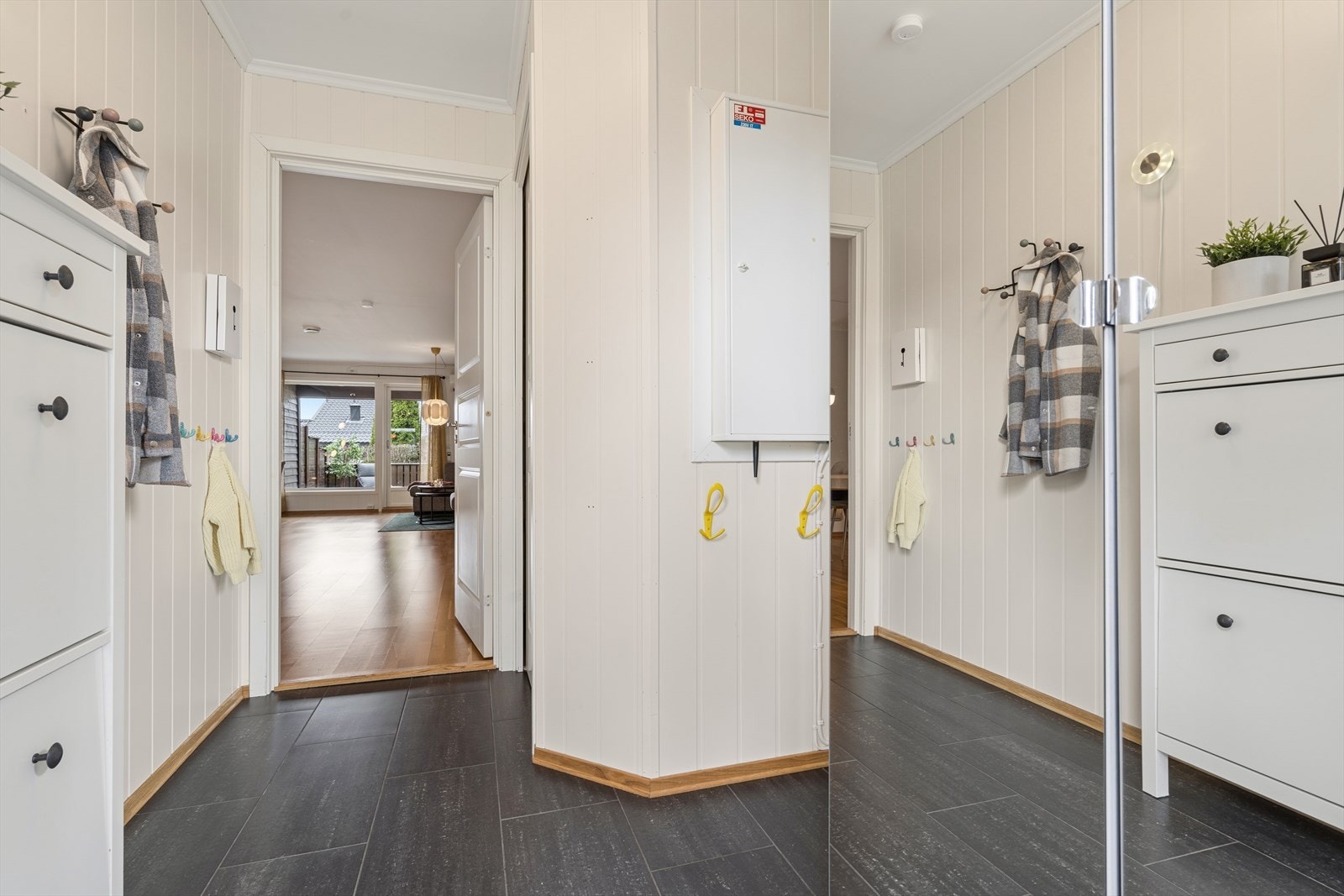 Lys entré med fliser på gulv og praktisk garderobeløsning. Galleribilde