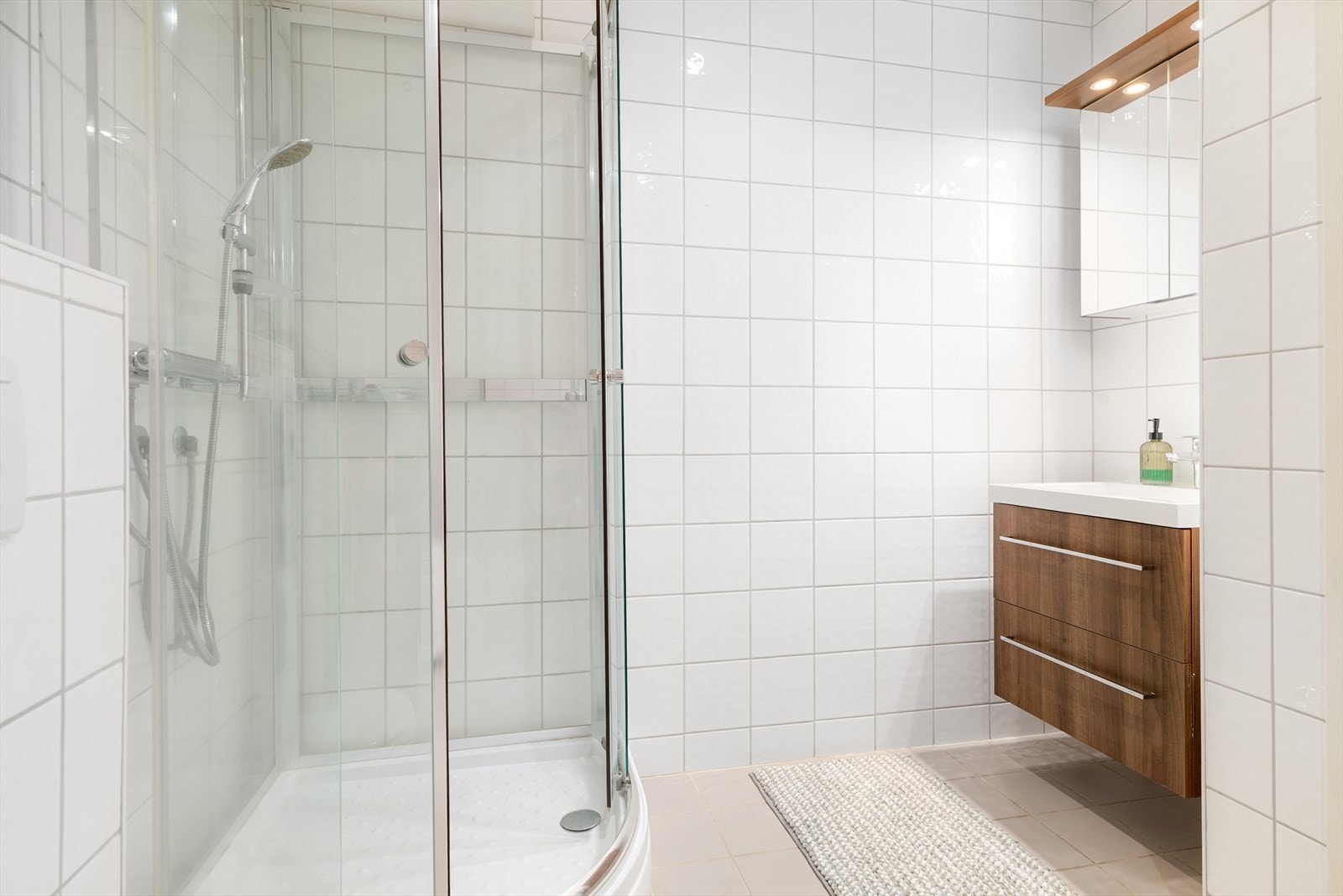 Badet er innredet med servant på servantskap, dusjhjørne, toalett og badekar. Galleribilde