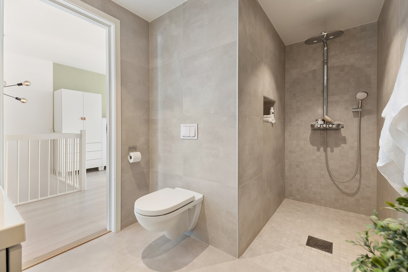 Rommet ble utvidet fra toalettrom til komplett bad ifm. bygging. Romslig dusjløsning med 1 meters bredde og veggnisje. Galleribilde