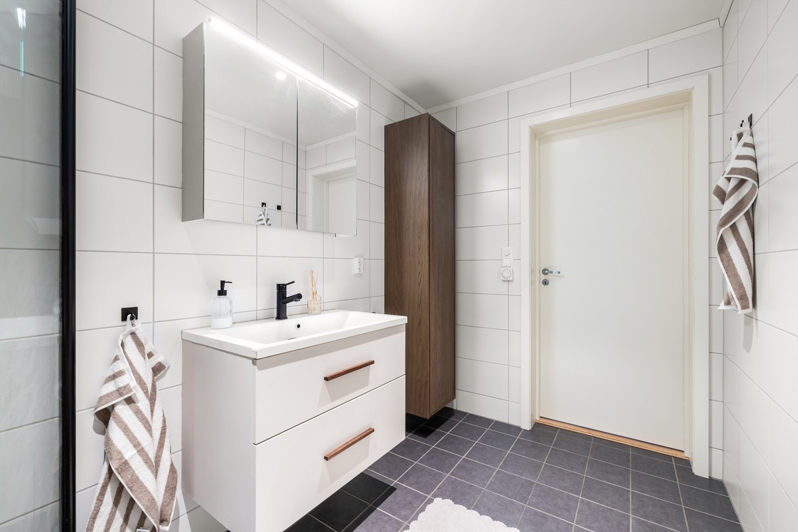 Det er behagelig gulvvarme under flisene og downlightsbelysning i taket. God plass til baderomsartiklene. Galleribilde