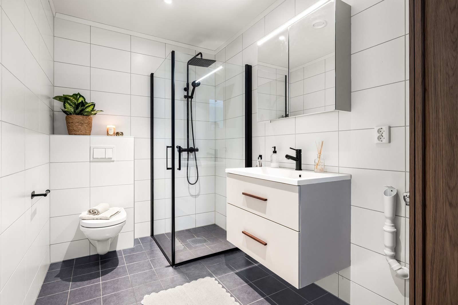 Mellom soverommene ligger et flott baderom, komplett utstyrt og med tidløse fliser på overflatene. Galleribilde