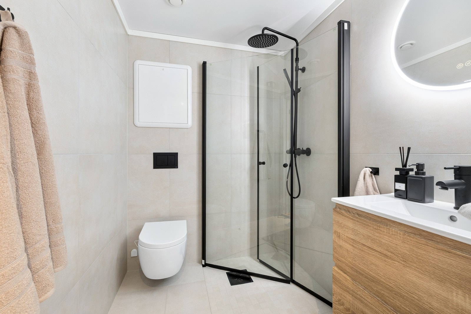 Badet fremstår som moderne og stilrent med en gjennomført material- og fargepalett. Galleribilde