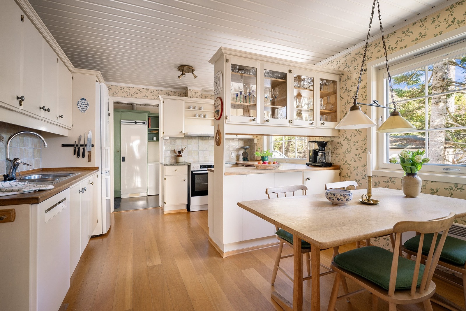 Lyst og velholdt kjøkken med plass til spisebord. Galleribilde