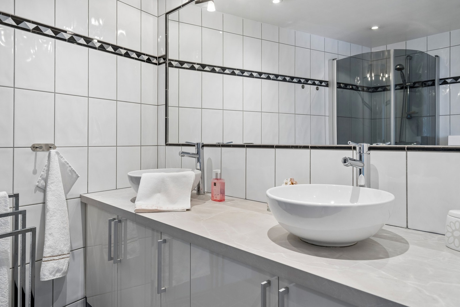 Flislagt bad med hvit innredning, toalett og dusjnisje Galleribilde