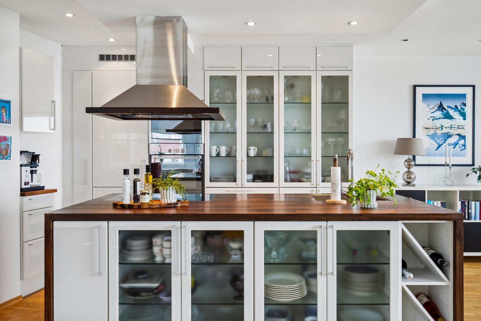 Moderne kjøkken med kjøkkenøy og masse lagringsplass i åpen løsning. Galleribilde