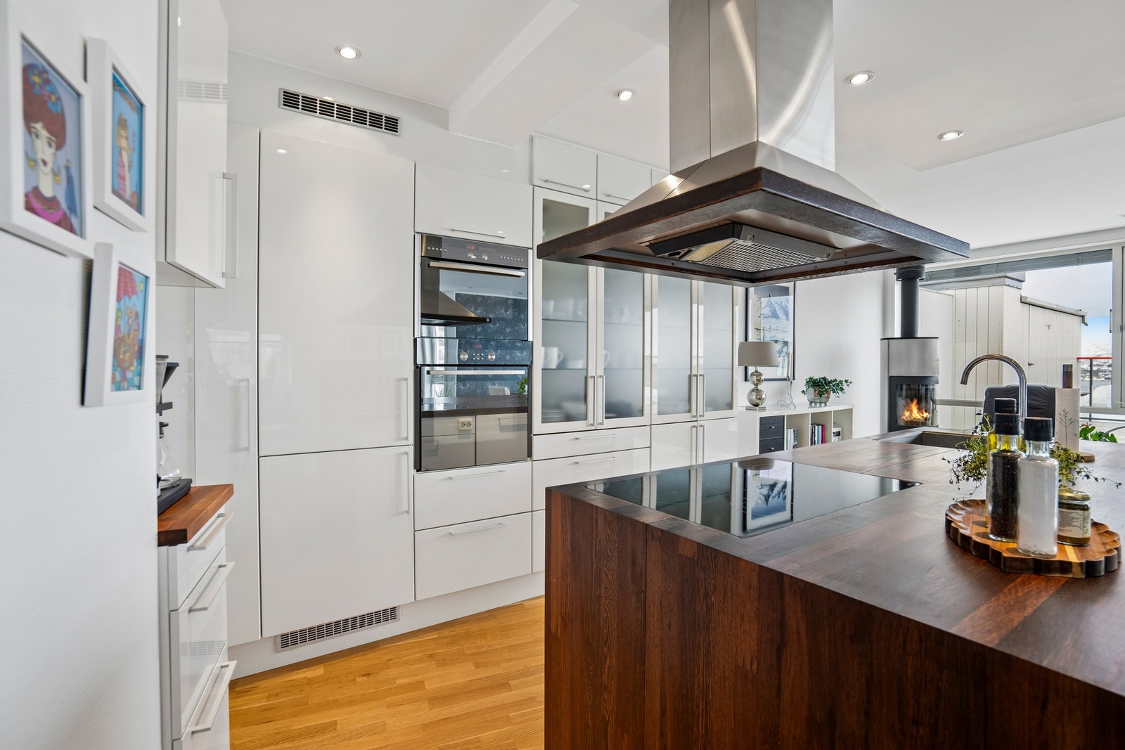 Lyst og innbydende kjøkken i hvitt med valnøtt kjøkkenøy Galleribilde