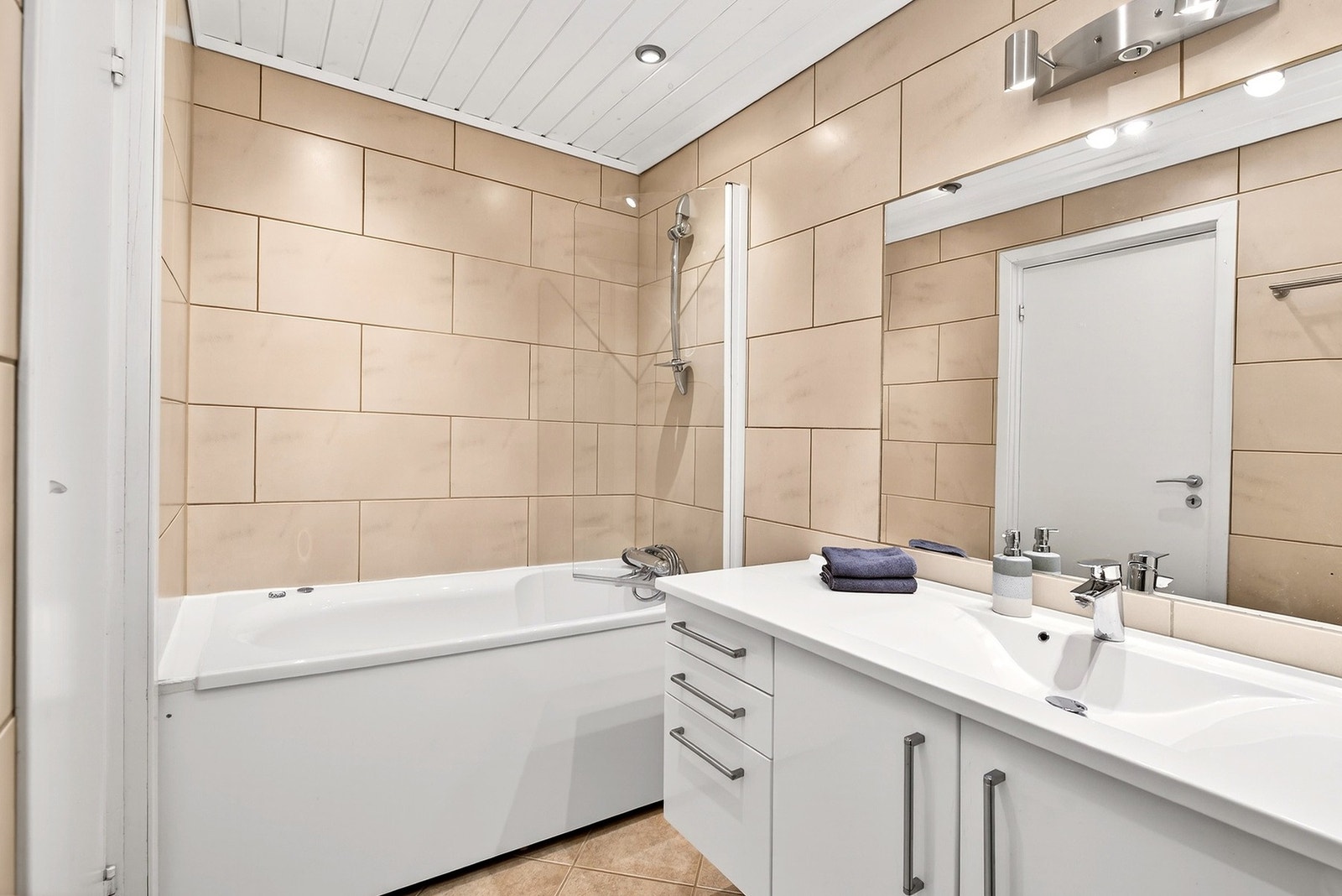 Flislagt bad med badekar og varme i gulv Galleribilde