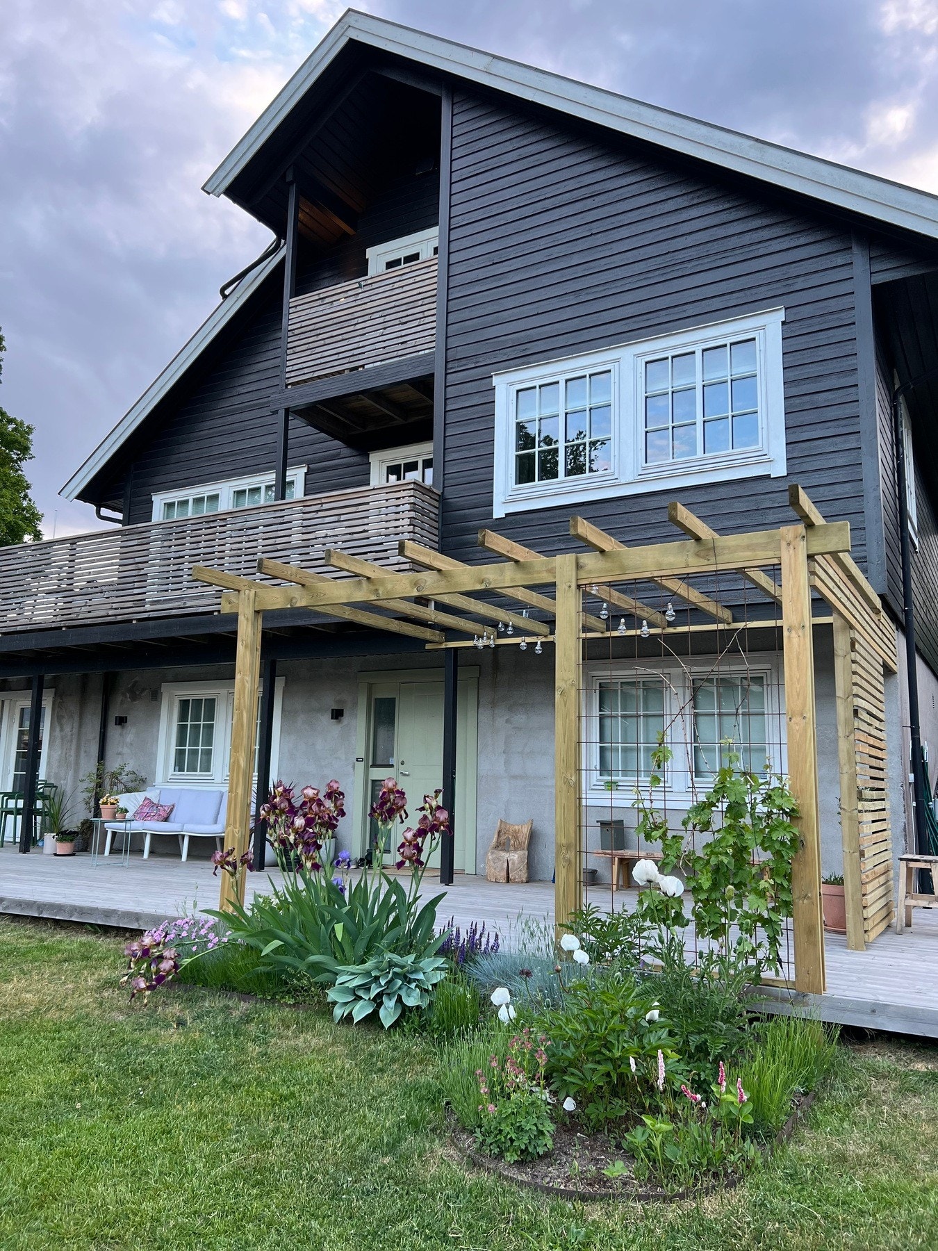 Innbydende uteområde med flott terrasse og frodig hage, perfekt for hyggelige stunder utendørs. Selgers sommerbilde Galleribilde