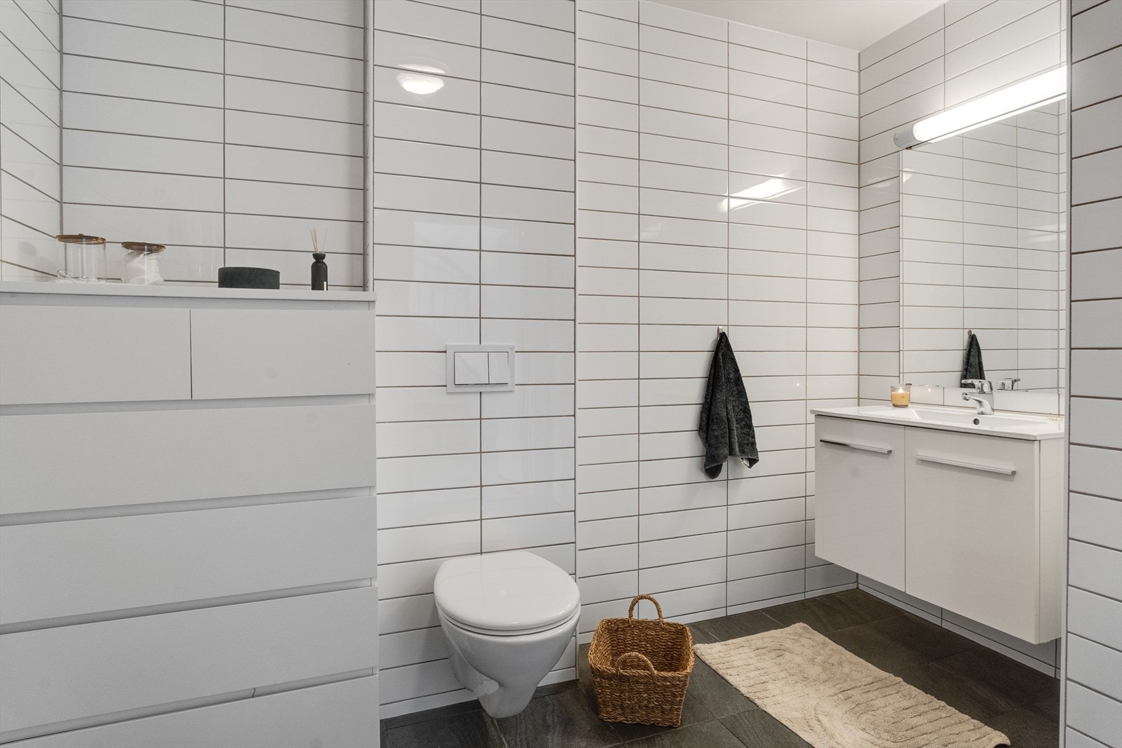 Flislagt bad med vegghengt toalett, dusj og vask Galleribilde