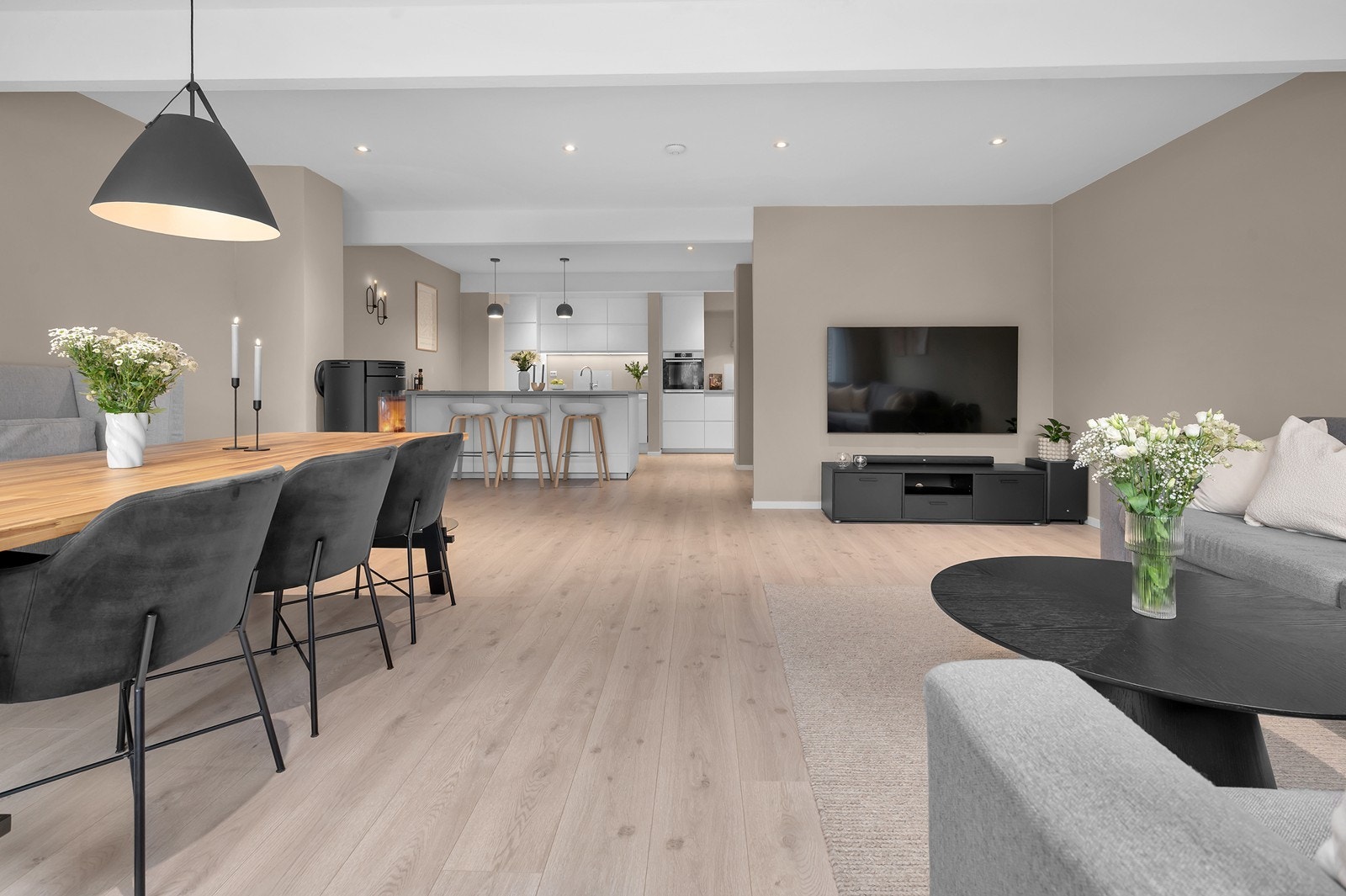 Åpen stue/kjøkkenløsning som gir en sosial atmosfære. Spotter i tak. Galleribilde