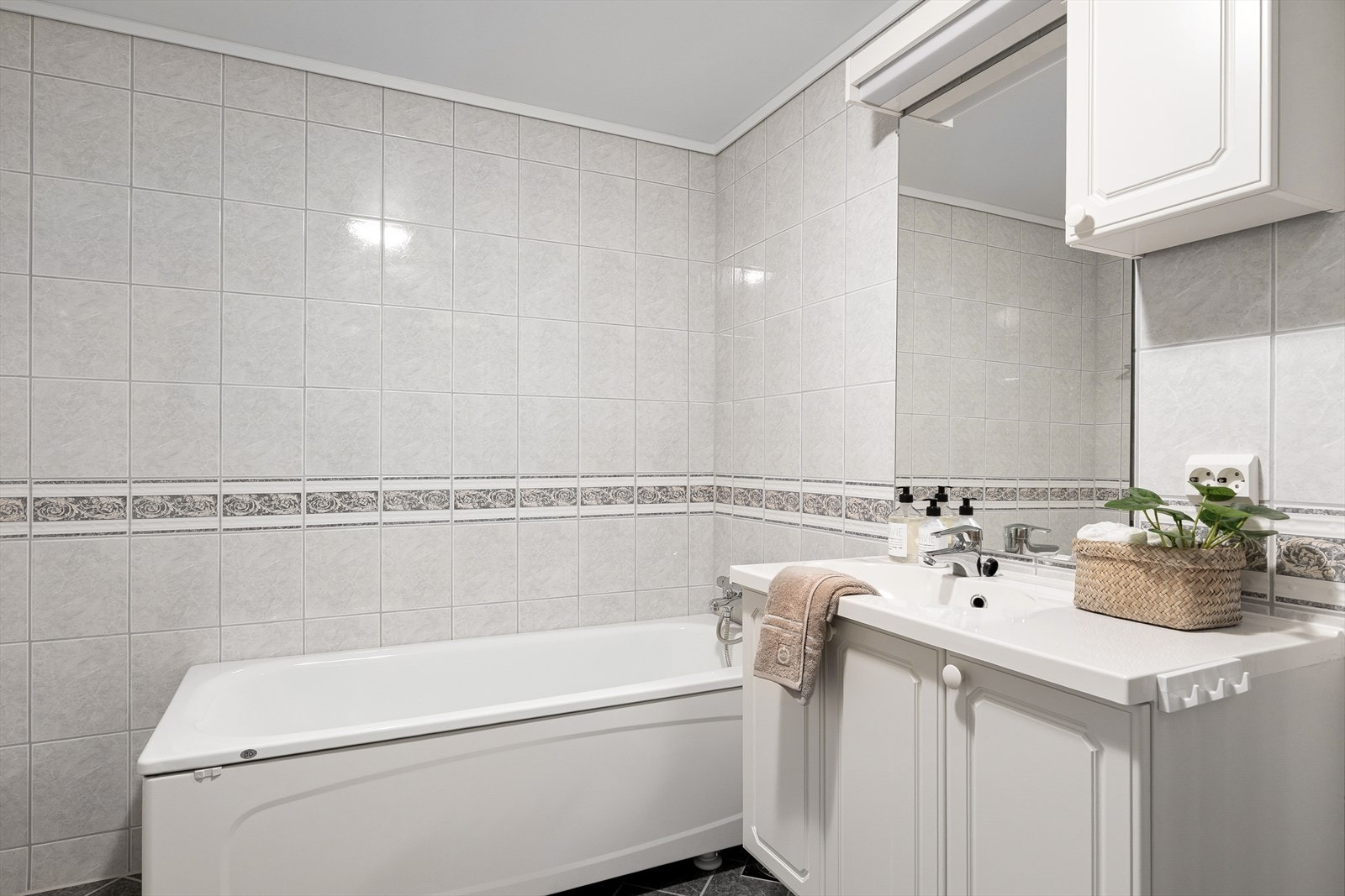 I tilknytning til soverommet finner du et bad utstyrt med fliser på gulv og vegger, varmekabler i gulv, badekar, dusj, toalett og servant. Galleribilde