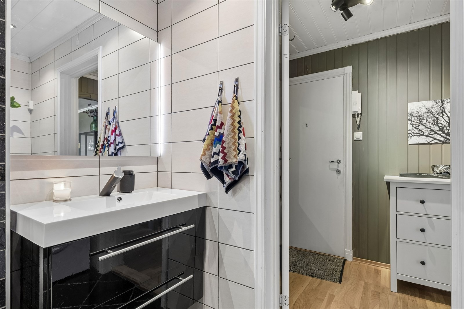 Baderomsinnredningen har heldekkende servant, høyglans skuffer og speil med integrert LED-lys. Galleribilde