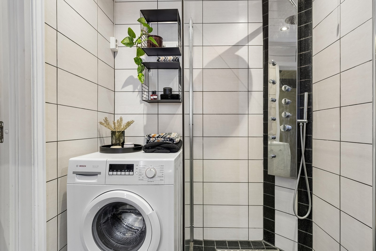 Her er det opplegg for vaskemaskin og et dusjhjørne med dusjgarnityr med massasjedyser. Galleribilde