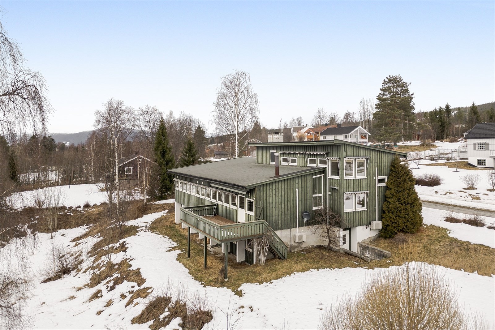 Verandaen har stående kledning med malt håndrekke, og det er trapp fra terreng med rekkverk. Galleribilde