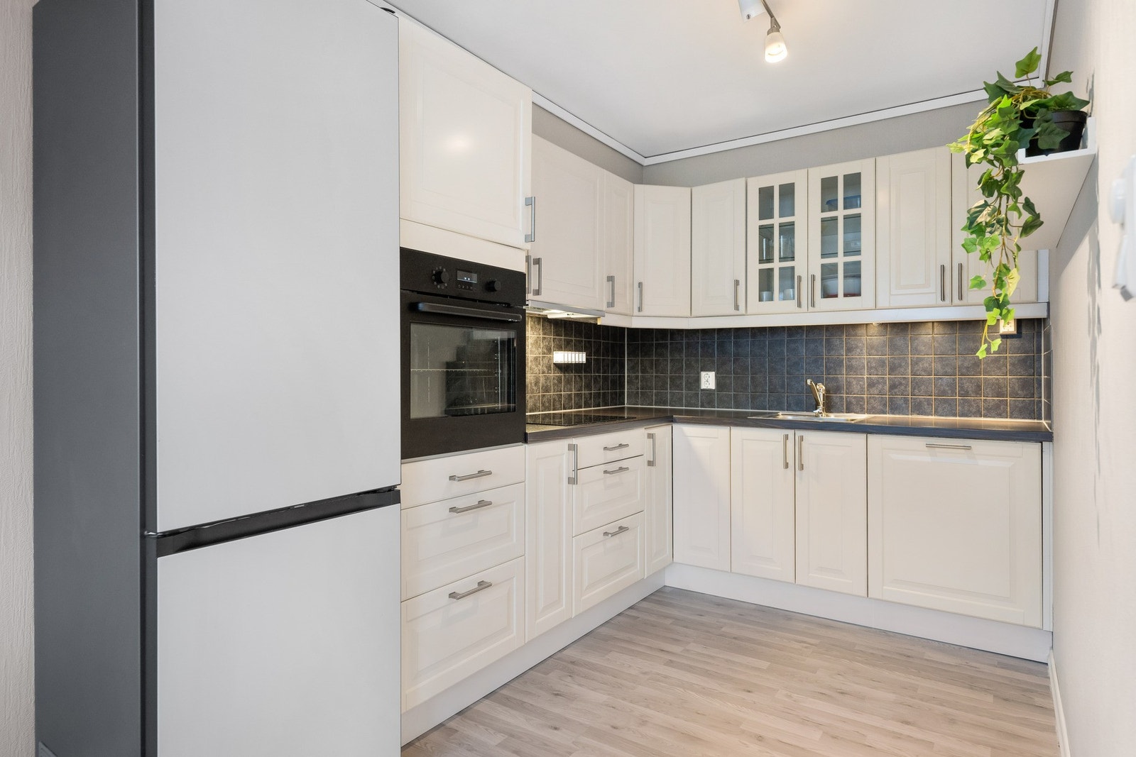 Lys kjøkkeninnredning med rikelig skapplass. Galleribilde