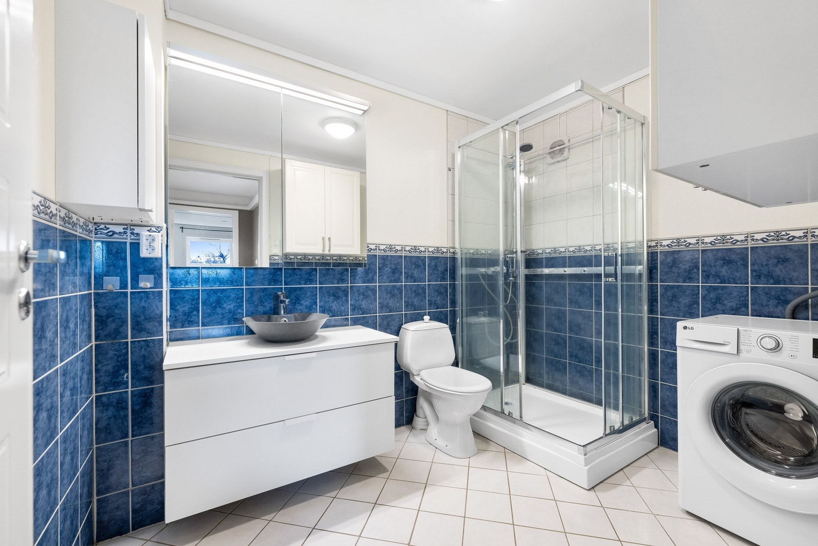 Helfliset bad utstyrt med servant, toalett, dusjkabinett og opplegg til vaskemaskin. Galleribilde