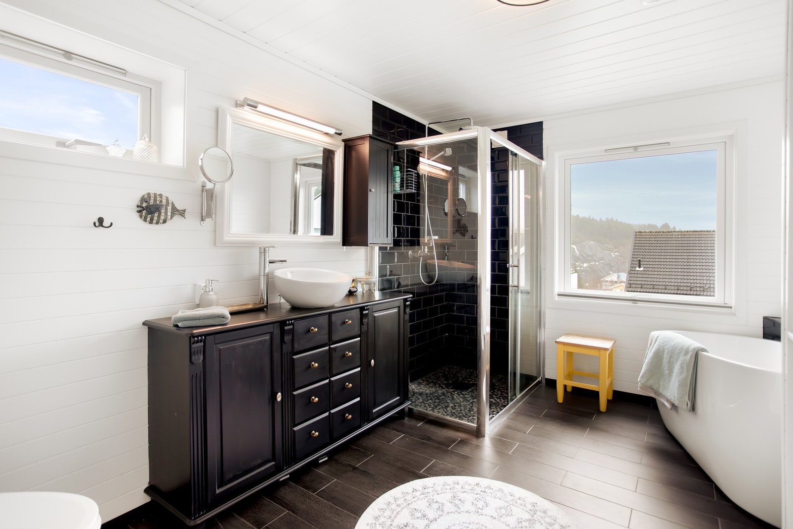 Badet har en romslig utforming og er utstyrt med servant, toalett, dusjkabinett, badekar og opplegg for vaskemaskin. Galleribilde