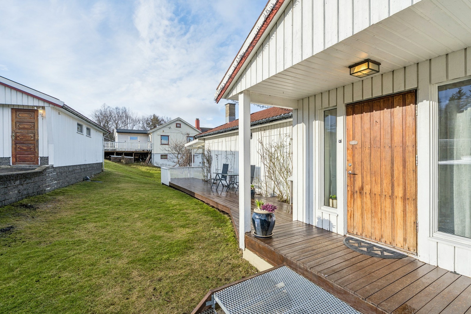 Inngangspartiet har et takoverbygg fra 2002 og en markplatting som leder ut i hagen. Galleribilde